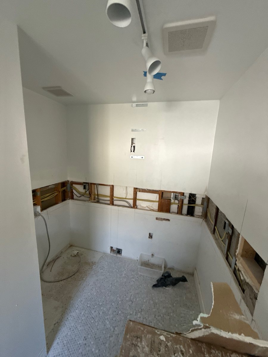 Kitchen wall before drywall repair, showing exposed openings